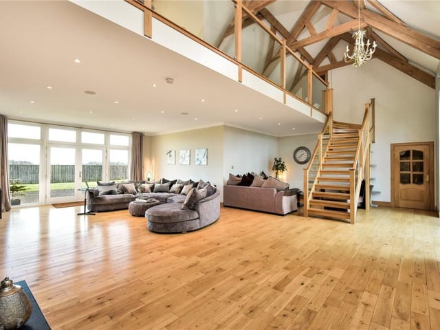 The sitting room is cleverly divided into two separate seating areas, and has views over the front garden, and doors out to the front and rear of the house.