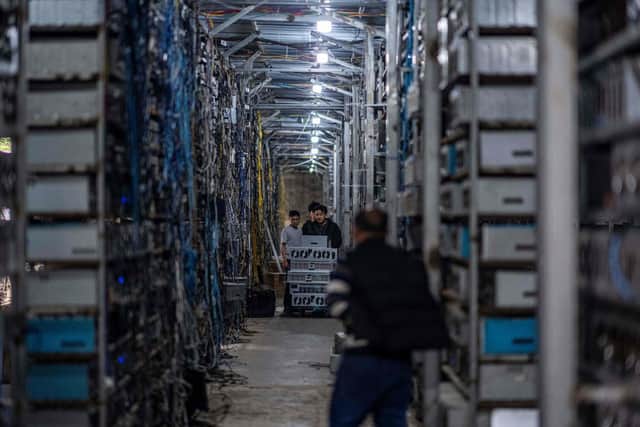 Workers transfer cryptocurrency mining rigs at a cryptocurrency farm which includes more than 3,000 mining rigs in Dujiangyan in China's southwestern Sichuan province. (Image credit: STR/AFP via Getty Images)
