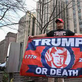 A Trump supporter stands outside of the Manhattan Criminal Court in New York ahead of the former US president's unprecedented appearance before a judge. Picture: Angela Weiss/AFP/Getty
