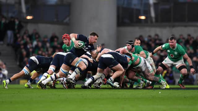 Jack Dempsey of Scotland runs with the ball clear of the scrum against Ireland.