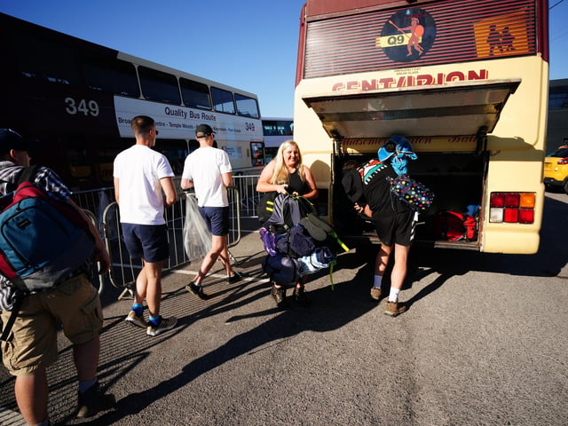 People board a bus at Castle Cary station heading to the Glastonbury Festival at Worthy Farm in Somerset.
