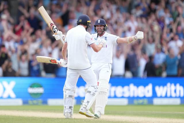 Chris Woakes and Mark Wood celebrate after guiding England to victory in Leeds.