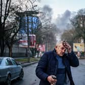 An injured man stands on a street after Russian shells hit the Ukrainian city of Kherson on Saturday. Five were killed and 20 injured in the attack (Picture: Dimitar Dilkoff/AFP via Getty Images)
