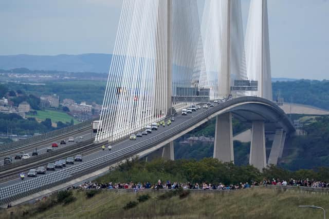 The hearse carrying the coffin of Queen Elizabeth II, draped with the Royal Standard of Scotland, passing over the Queensferry Crossing as it continues its journey to Edinburgh from Balmoral on Sunday