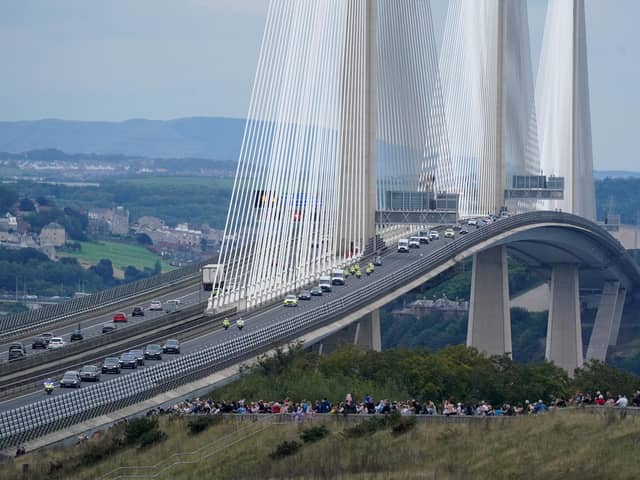 The hearse carrying the coffin of Queen Elizabeth II, draped with the Royal Standard of Scotland, passing over the Queensferry Crossing as it continues its journey to Edinburgh from Balmoral on Sunday