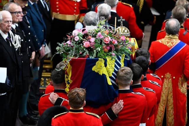 The coffin of Queen Elizabeth II with the Imperial State Crown resting on top is carried by the Bearer Party into Westminster Abbey during the State Funeral of Queen Elizabeth II.