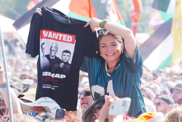 A Kneecap fan at Glastonbury, brandishing merchandise the band sells referring to their recent controversies. Photo: Ben Birchall/PA Wire