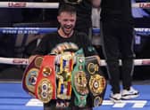 Josh Taylor celebrates while holding his belts after defeating Jose Ramirez by unanimous decision