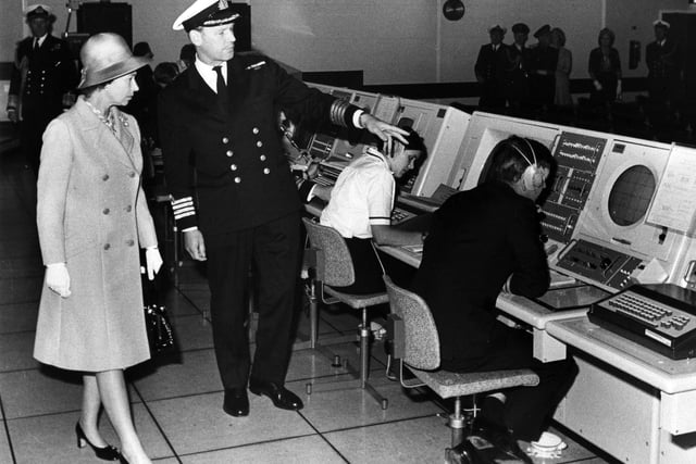 Captain S.A. Stuart, Director of the Maritime Tactical School escorts Queen Elizabeth and explains 'war games' during her visit to the Monitor room at HMS Dryad on the 20th July 1973. Picture: The News 7964-16