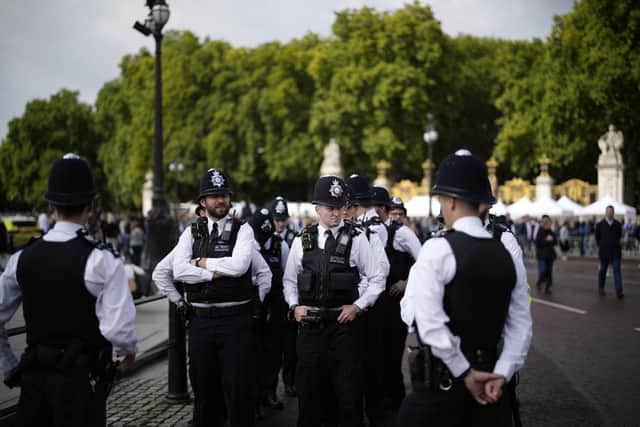 Police officers wait outside Buckingham Palace in London. Picture: AP Photo/Christophe Ena