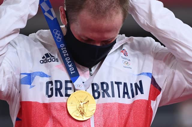 Jason Kenny puts on his gold medal after the men's track cycling keirin final