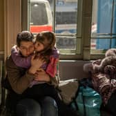 A Ukrainian evacuee hugs a child at the train station in Przemysl, near the Polish-Ukrainian border (Picture: Angelos Tzortzinis/AFP via Getty Images)