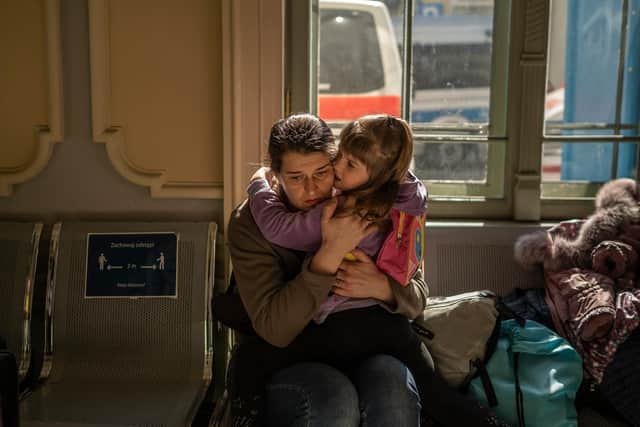 A Ukrainian evacuee hugs a child at the train station in Przemysl, near the Polish-Ukrainian border (Picture: Angelos Tzortzinis/AFP via Getty Images)