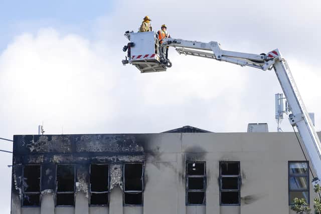 Firefighters survey the roof after a fire at Loafers Lodge in Wellington, New Zealand. Picture: Hagen Hopkins/Getty Images