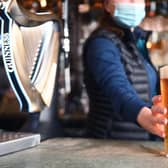 A bar person serves up a pint of Tennants lager. Picture: John Devlin