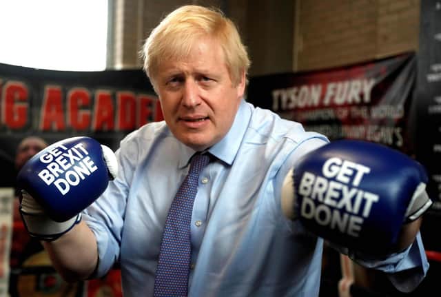 Photo taken on November 19, 2019 - Boris Johnson wears boxing gloves emblazoned with "Get Brexit Done" Photo by Frank Augstein via Getty Images