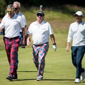 Former Scottish rugby Gavin Hastings, Aberdeen Asset Management chief executive Martin Gilbert with Ireland's Rory McIlroy make their way to the 15th