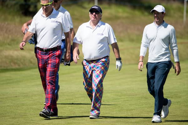 Former Scottish rugby Gavin Hastings, Aberdeen Asset Management chief executive Martin Gilbert with Ireland's Rory McIlroy make their way to the 15th