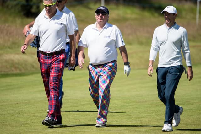 Former Scottish rugby Gavin Hastings, Aberdeen Asset Management chief executive Martin Gilbert with Ireland's Rory McIlroy make their way to the 15th