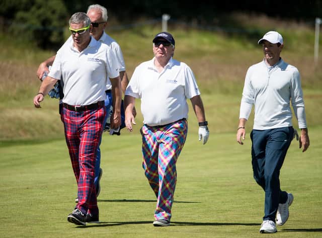 Former Scottish rugby Gavin Hastings, Aberdeen Asset Management chief executive Martin Gilbert with Ireland's Rory McIlroy make their way to the 15th