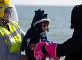 A rescuer gives a baby back to the mother on the beach after disembarking from an RNLI lifeboat, in Dungeness, on the southeast coast of England, last month, after crossing the English Channel.