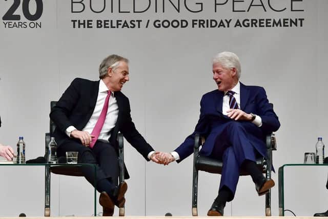 Former US President Bill Clinton holds hands with former British Prime Minister Tony Blair at an event in Belfast in 2018 to mark the 20th anniversary of the Good Friday Agreement.