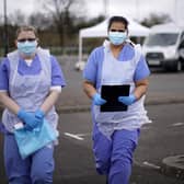 NHS nurses wait for the next patient at a drive through Coronavirus testing site in a car park in Wolverhampton, England. The National Health Service facility has been set up in a car park to allow people with NHS referrals to be swabbed for Covid-19.