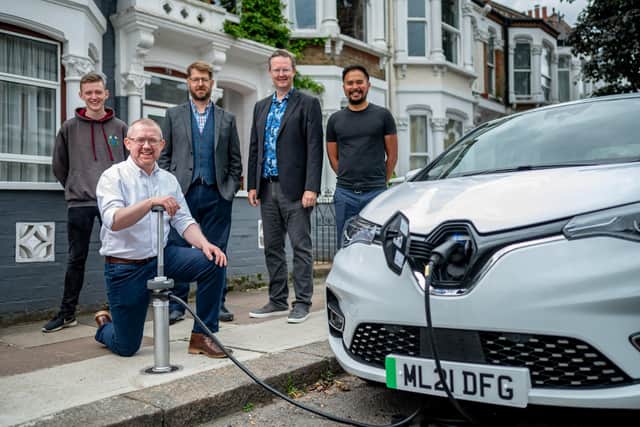 CEO Ian Mackenzie (kneeling) and team members demonstrating one of the firm's flat-and-flush EV charging points. Picture: Darren Cool.