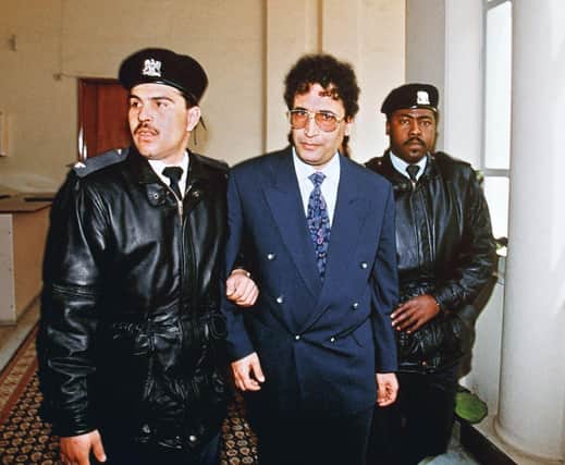 Abdelbasset al-Megrahi is escorted by security officers before appearing at a 1992 court hearing in connection with the bombing of Pan Am flight 103 over Lockerbiein 1988 (Picture: Manoocher Deghati/AFP via Getty Images)
