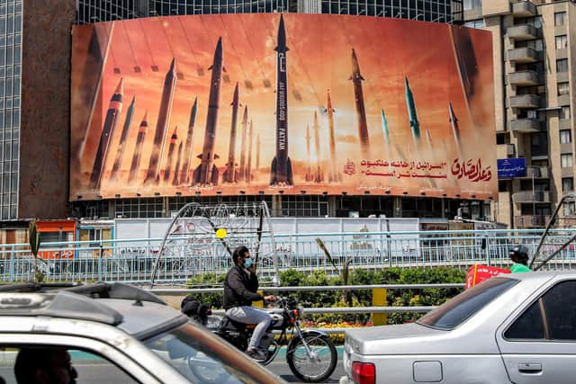 A billboard in central Tehran shows named ballistic missiles with a caption 'Israel is weaker than a spider's web' (Picture: Atta Kenare/AFP via Getty Images)