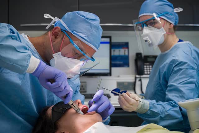 Dentist Fiez Mughal (L) and Dental Nurse Johanna Bartha (R) carry out a procedure on a patient in one of the six surgery rooms at East Village dental practice on May 28, 2020 in London.. (Photo by Leon Neal/Getty Images)