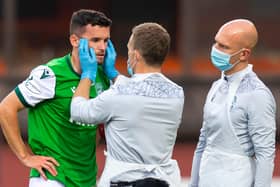 Hibs defender Paul McGinn is assessed by the physio after a clash of heads during a match with Dundee United earlier this season