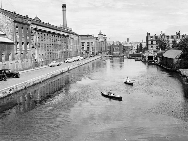 Boys in canoes on the Union Canal at Viewforth in July 1957 with the North British Rubber Company's Castle Mills on the left.