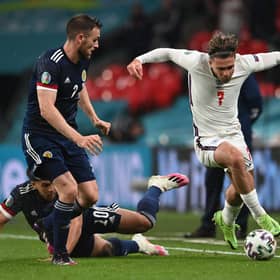 Jack Grealish runs with the ball whilst under pressure from Stephen O'Donnell and Che Adams