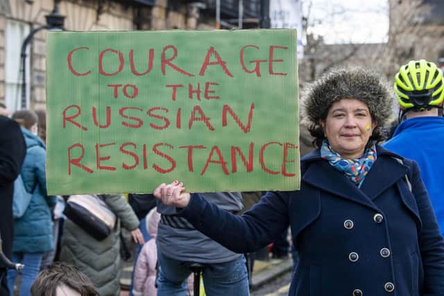 A woman sends a message to Russians opposed to Vladimir Putin during a demonstration outside the Russian Consulate General in Edinburgh (Picture: Lesley Martin/PA Wire