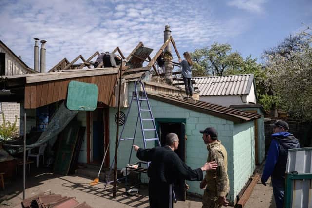 Residents and rescue workers secure homes the day after a shelling attack in the village of Zaporizhzhia, in southern Ukraine, where two British aid workers have reportedly been captured.
