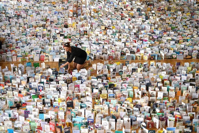 Mandy Alison adds to the thousands of birthday cards sent to Captain Tom Moore for his 100th birthday on April 30, 2020, which were displayed in the Hall of Bedford School. (Photo by Shaun Botterill/Getty Images)