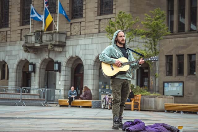 McCarron as Zoso, a homeless busker, playing guitar in the City Square, Dundee, for Dog Days. Pic: Contributed