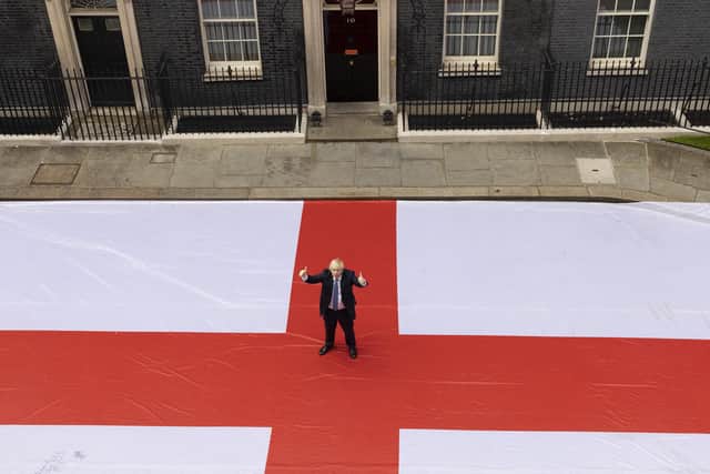 Boris Johnson poses for a photograph outside 10 Downing Street with a giant St George's flag