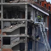 Firefighters approach a damaged building in Madrid on January 20, 2021 after a strong explosion rocked it. (Photo by GABRIEL BOUYS / AFP).