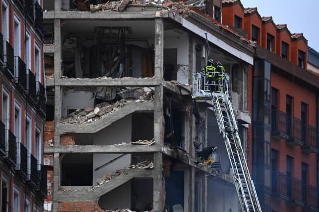 Firefighters approach a damaged building in Madrid on January 20, 2021 after a strong explosion rocked it. (Photo by GABRIEL BOUYS / AFP).