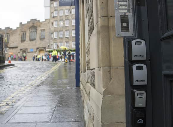 Key boxes for Airbnb properties outside a tenement flat in Upper Bow, Edinburgh