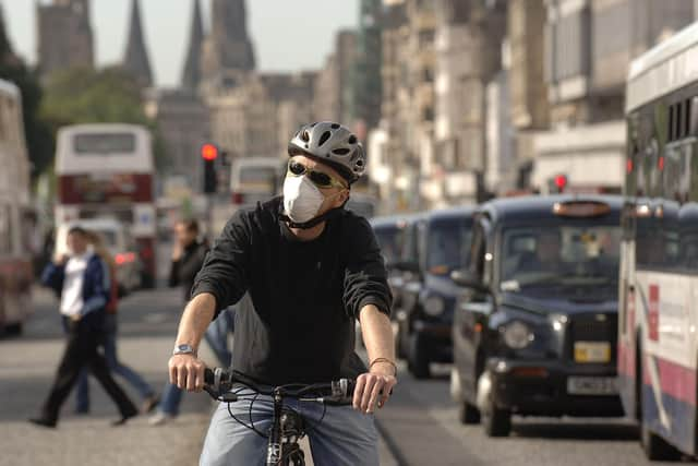 A cyclist on Princes Street wearing an anti-pollution mask. Scotland is well-placed to lead the way in creating cleaner air, writes Richard Dixon. PIC: Jon Savage.