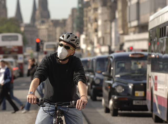 A cyclist on Princes Street wearing an anti-pollution mask. Scotland is well-placed to lead the way in creating cleaner air, writes Richard Dixon. PIC: Jon Savage.