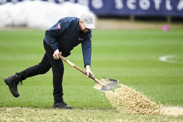 Grounds staff tend to the pitch at Dens Park ahead of Dundee v Motherwell.