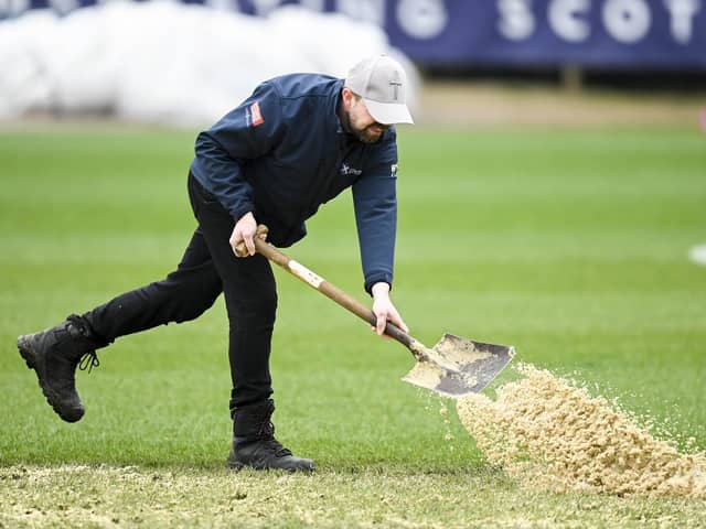 Grounds staff tend to the pitch at Dens Park ahead of Dundee v Motherwell.