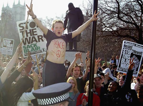 A young protester with 'peace' written on his chest demonstrates outside the Houses of Parliament with military action against Iraq loomng in 2003