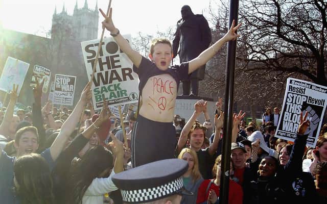 A young protester with 'peace' written on his chest demonstrates outside the Houses of Parliament with military action against Iraq loomng in 2003