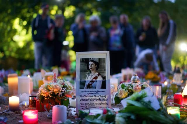 Floral tributes and candles from members of the public are laid in Green Park near to Buckingham Palace