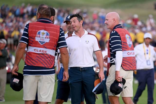 An animated Rory McIlroy speaks to Patrick Cantlay, who is partly hidden by Wyndham Clark's caddie, as Joe LaCava looks on. Picture: Ross Kinnaird/Getty Images.